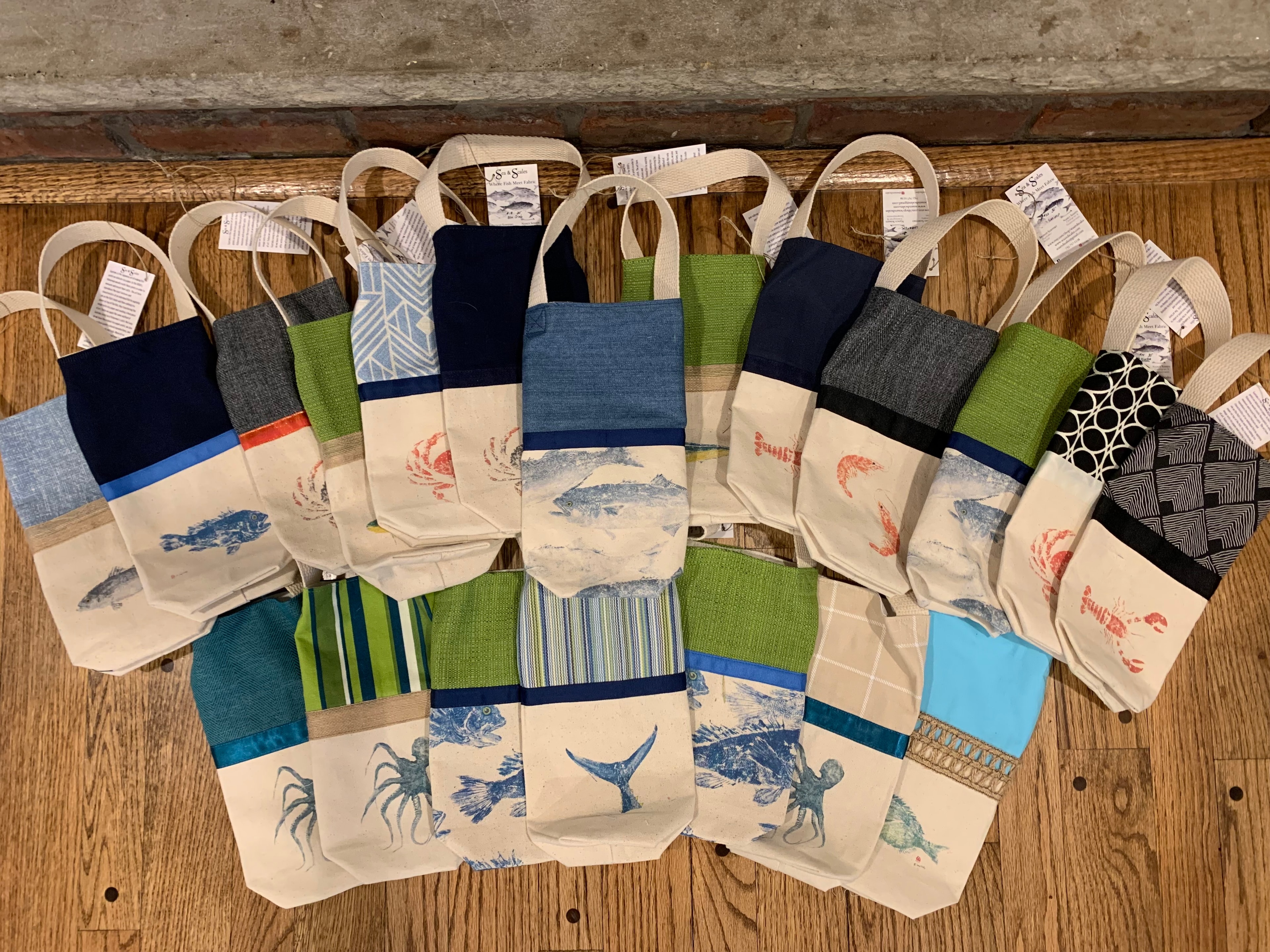 Full collection of Sea & Scales canvas wine tote bags fanned out